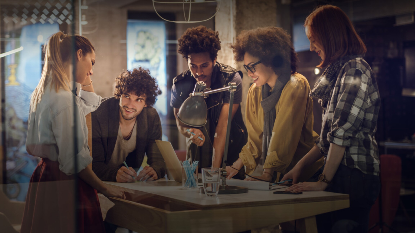 A diverse group of people collaborating around a desk 