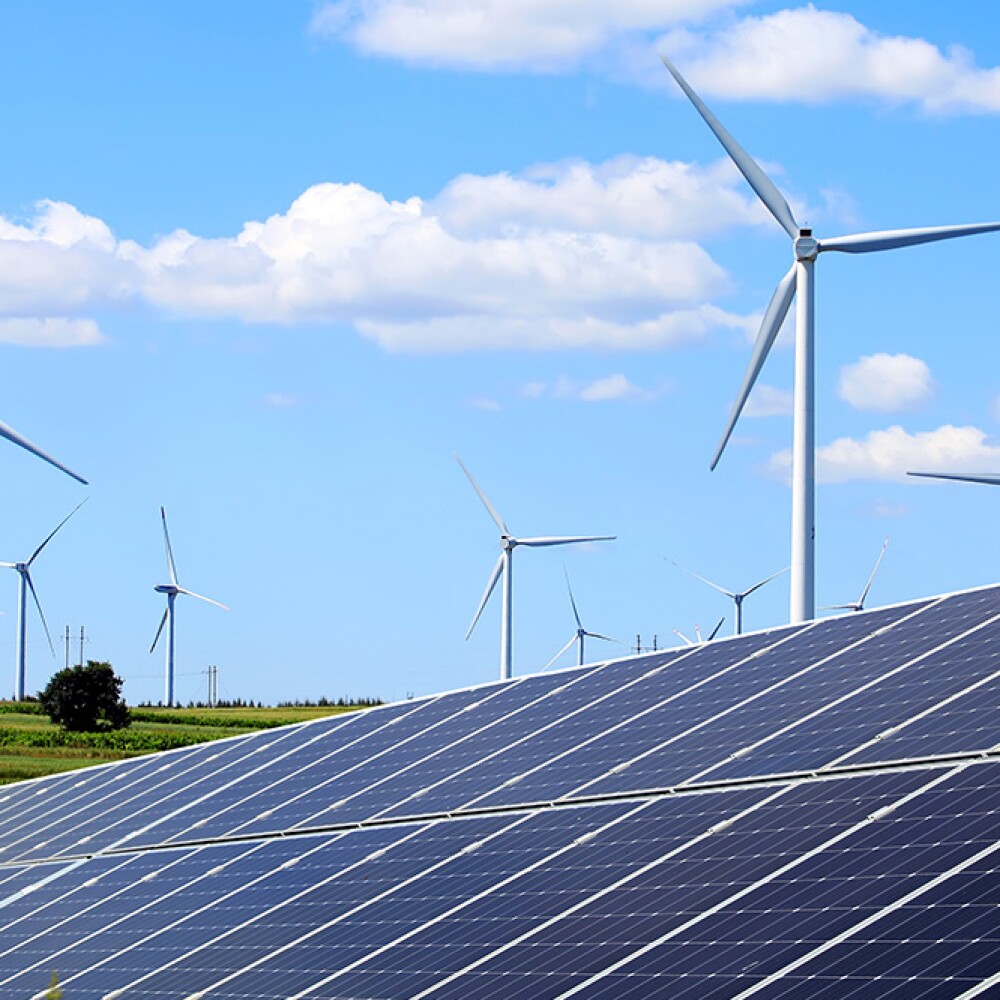 Solar panels and wind turbines generate renewable energy on a sunny day