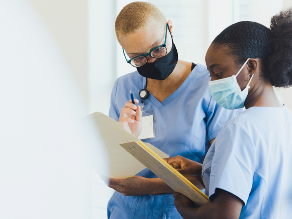 Two female nurses looking at a patient's chart 