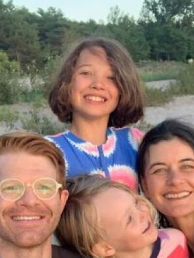 A family of four taking a selfie on the beach 