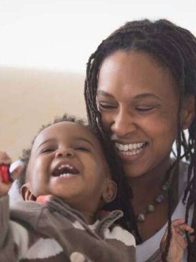 A woman and her toddler laughing 