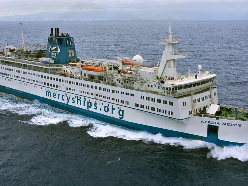 Aerial view of a Mercyships.org floating hospital ship sailing through the ocean 