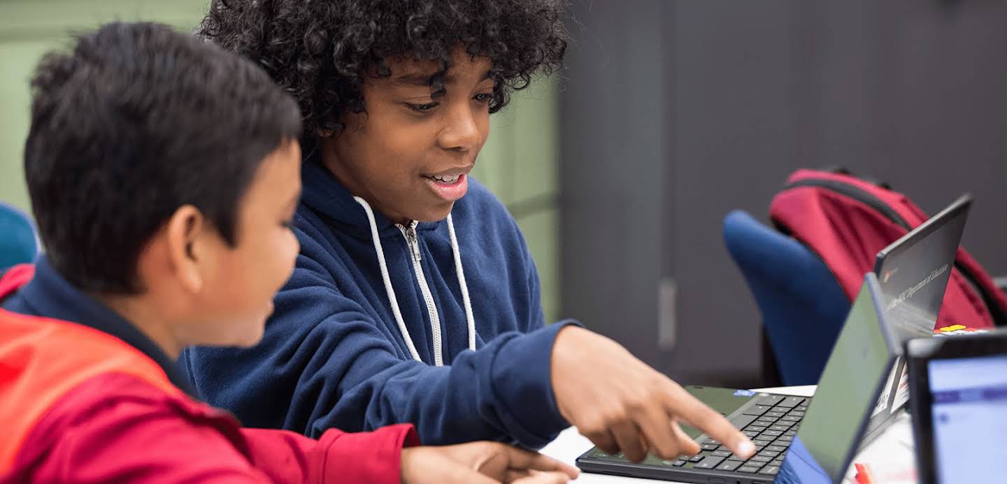 Two students using their chromebooks in school.