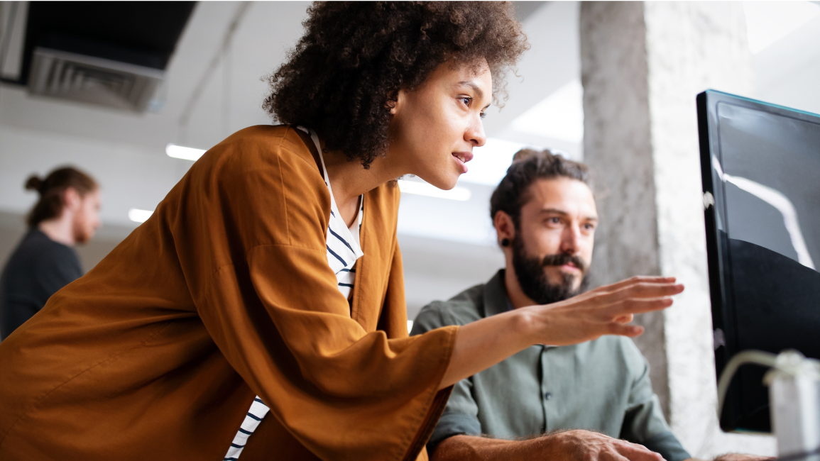 Team members collaborating at an office workstation