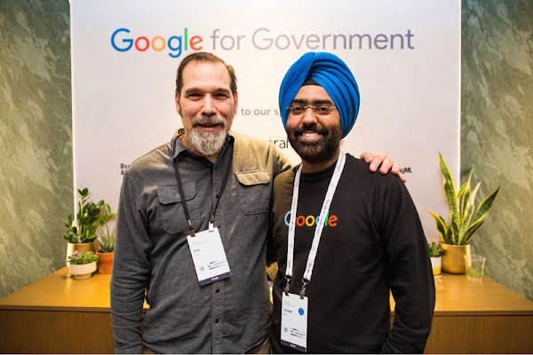 Two job seekers with event lanyards at a Google for Government job fair.