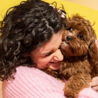 A Woman hugging a brown dog