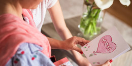 Family reading homemade Mother's day card together