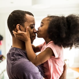 daughter kissing father on the nose