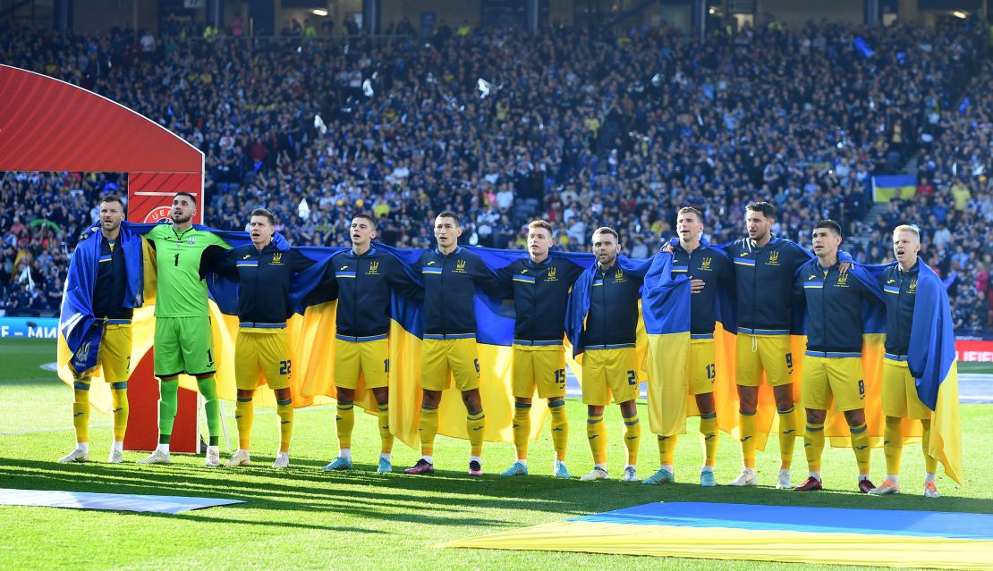 Ukrainian players lined up draped in their country's flag ahead of the game. 