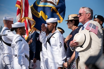Soldiers, Sailors, Airmen, a Coast Guardsman and an Army veteran salute the colors during a naturalization ceremony aboard USS Constitution.