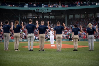 Chief of Naval Operations Adm. Mike Gilday administers the oath of enlistment to future U.S. Navy Sailors prior to a Red Sox baseball game at Fenway Park, Boston.