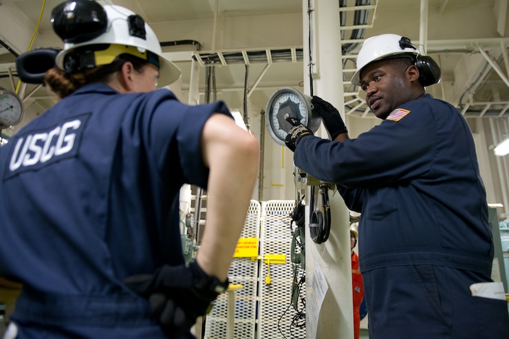 Petty Officer 1st Class Edgar Douglas, a marine science technician, shows his shipmate what to look for during an inspection aboard.