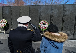 WASHINGTON (Mar. 29, 2022) Chief of Naval Operations Adm. Mike Gilday, left, salutes next to Mrs. Ann Smith during a wreath laying at the Vietnam Veterans Memorial on National Vietnam War Veterans Day. Anne Smith is the widow of Lt. Cmdr. James A. Smith, who was killed in action aboard the USS Oriskany during the Vietnam War. (U.S. Navy photo by Mass Communication Specialist 1st Class Sean Castellano/Released)
