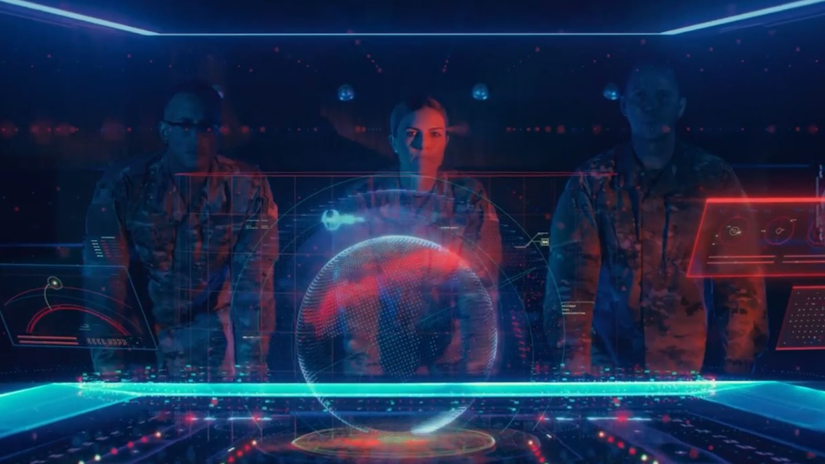 Three military individuals look at a hologram interface.