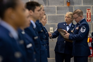 U.S. Air Force Master Sgt. Shannon Fairburn and Master Sgt. Lewis Staubs ensure Airmen in the 167th Materiel Management Flight are wearing their service dress uniforms in accordance with dress and appearance standards during a uniform inspection, Nov. 6, 2022, at the 167th Airlift Wing, Shepherd Field, Martinsburg, West Virginia