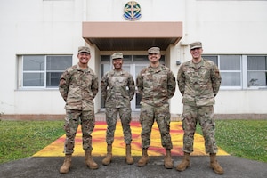 Airman 1st Class Jaylin Velazquez, 718th Aircraft Maintenance Squadron aerospace propulsion journeyman, Airman 1st Class Myasia Riddick, 18th AMXS weapons load crew member, Airman 1st Class Gregory Polk, 718th AMXS electronic warfare specialist and Airman 1st Class Eric Melao, 718th AMXS electrical and engineering specialist stand in front of dorm 179 at Kadena Air Base, Japan, May 5, 2022.