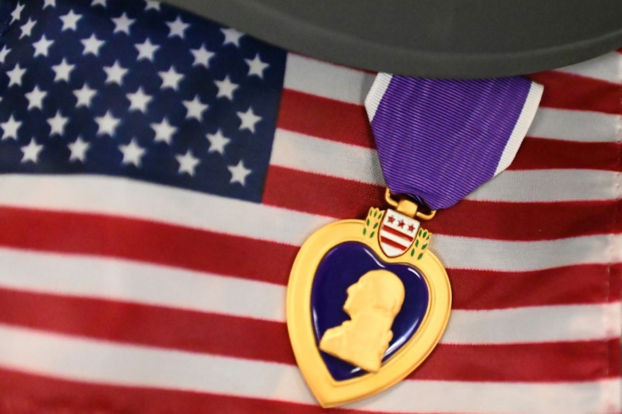 The Purple Heart medal lays over the American flag.