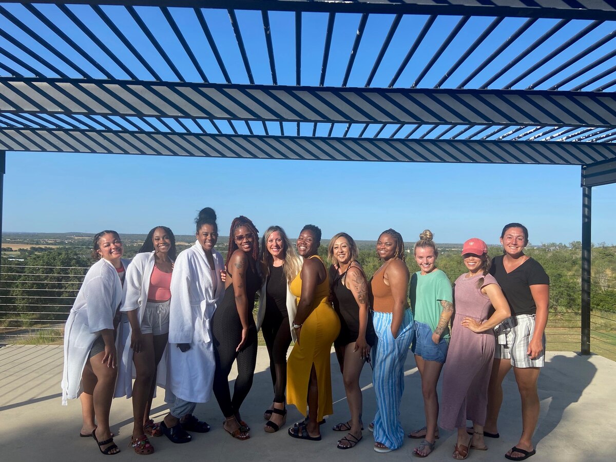 A group of women standing in a line smiling.