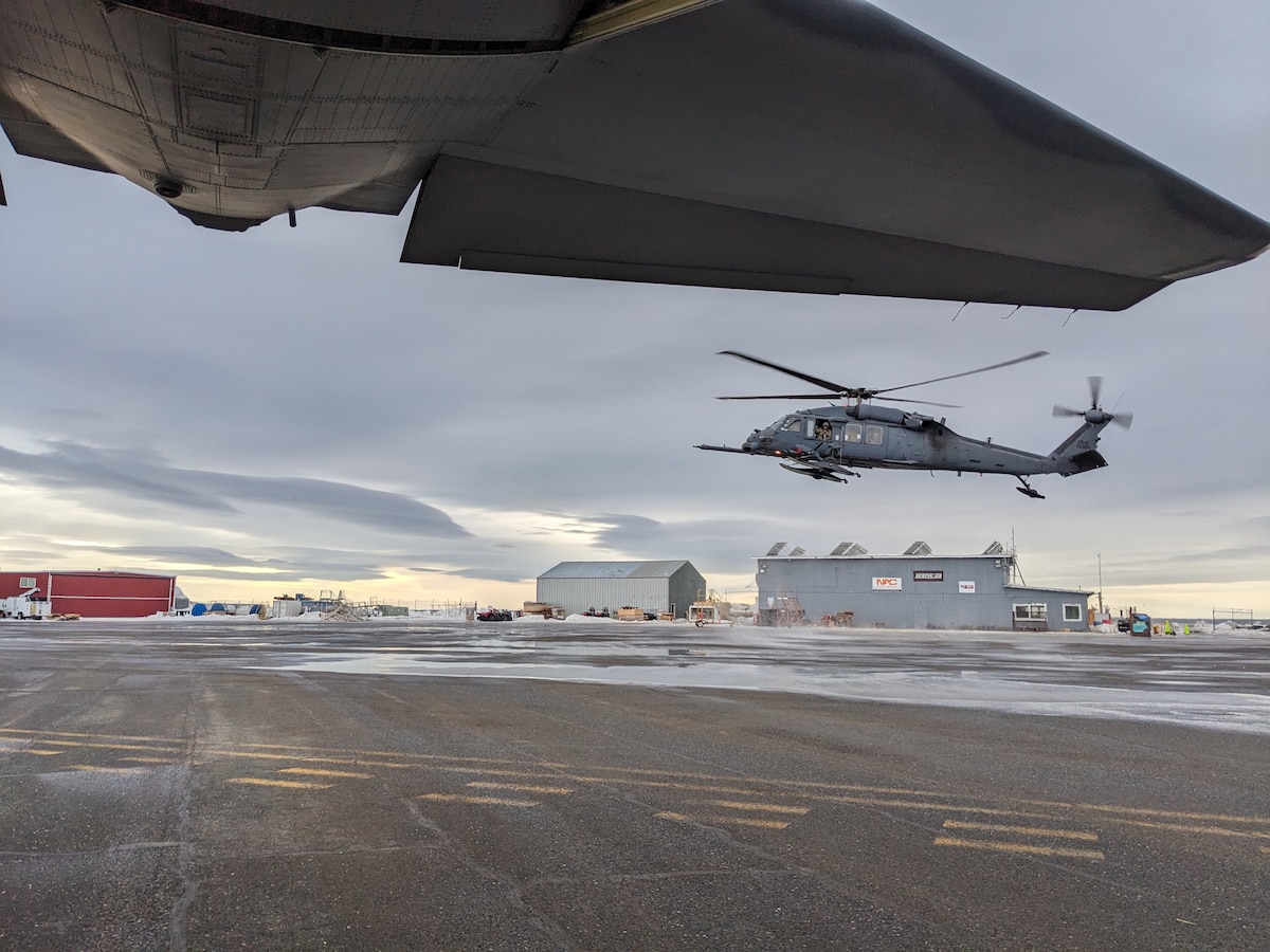 Framed by the tail of a 211th Rescue Squadron HC-130J Combat King II, a 210th Rescue Squadron HH-60G Pave Hawk, carrying 212th Rescue Squadron Guardian Angel personnel recovery Airmen, sorties from Unalakleet, Alaska, March 21, 2024. The HH-60 transloaded Guardian Angels to the HC-130 before continuing to Kotlik for a medical evacuation mission. Framed by the tail of a 211th Rescue Squadron HC-130J Combat King II, a 210th Rescue Squadron HH-60G Pave Hawk, carrying 212th Rescue Squadron Guardian Angel personnel recovery Airmen, sorties from Unalakleet, Alaska, March 21, 2024. The HH-60 transloaded Guardian Angels to the HC-130 before continuing to Kotlik for a medical evacuation mission.