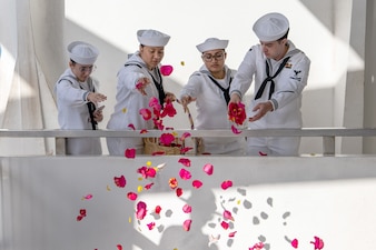 Sailors release flowers into the viewing well of the USS Arizona Memorial during a memorial service for retired Lt. Cmdr. Louis “Lou” Conter, the last survivor of the Dec. 7, 1941 Japanese attack on the USS Arizona (BB 39).
