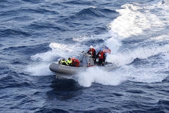 Sailors from USS Curtis Wilbur (DDG 54) transport stranded boaters.