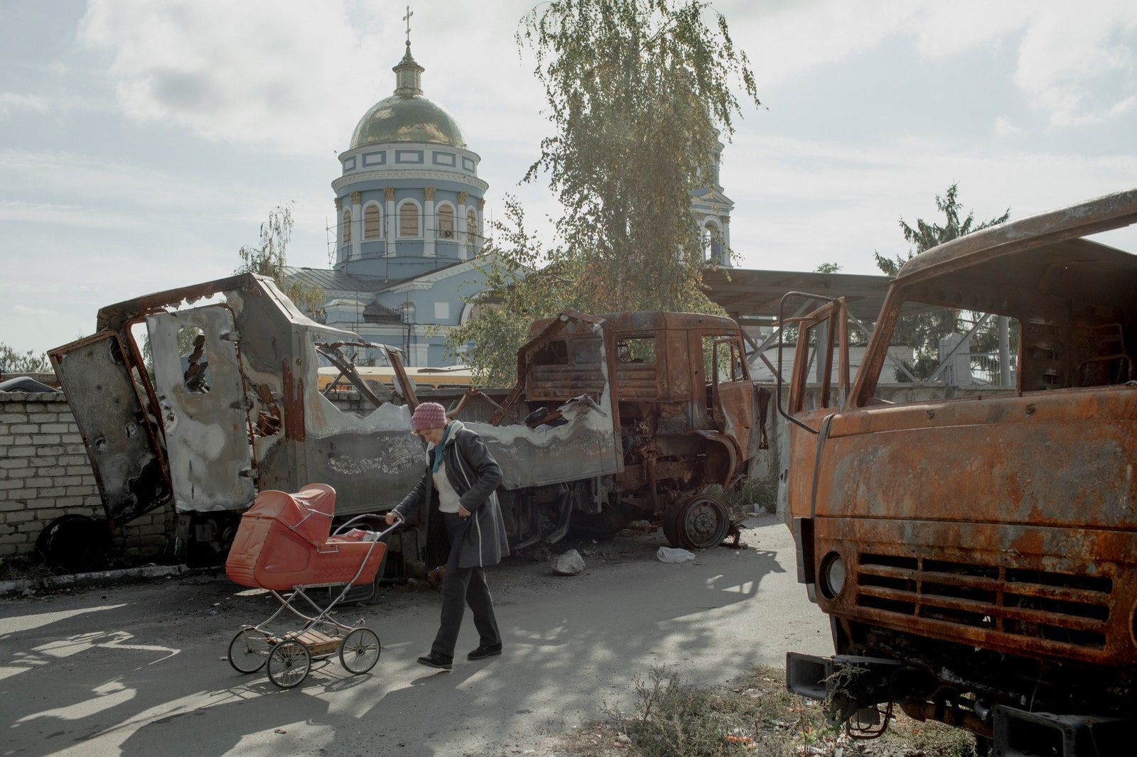 A woman pushes groceries in a baby carriage in the center of Izyum.