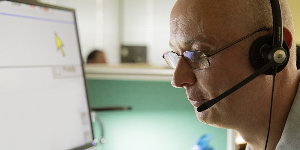 Man looking at screen wearing headset