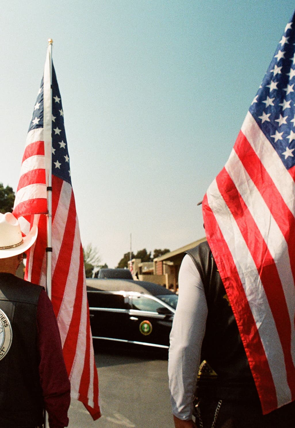 Two people standing with the American flags