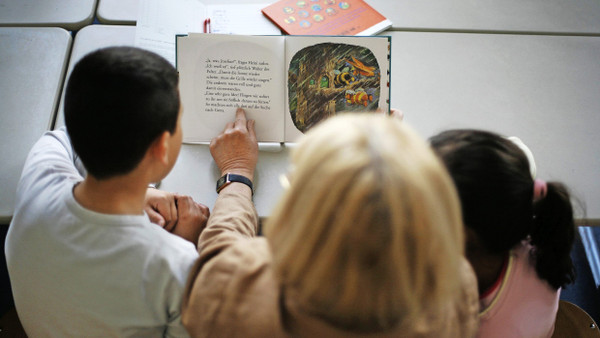 Altbewährt und doch wieder neu: Eine Lesepatin trainiert mit Berliner Grundschülern das laute Lesen mit Lesefinger.