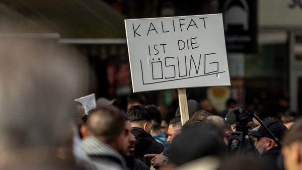 Hamburg: Teilnehmer einer Islamisten-Demo halten ein Plakat mit der Aufschrift „Kalifat ist die Lösung“ in die Höhe.