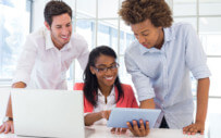 three people looking at a tablet