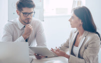 man and woman looking at something on an ipad