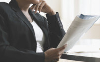 woman at a desk reading a document