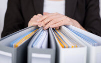 woman with her hands on top of binders