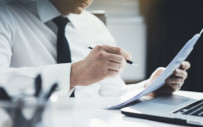 man sitting at a desk reviewing a document