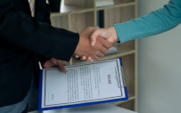 Two business professionals shake hands.