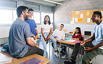 A faculty member speaking to college students after class.