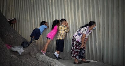 Дети смотрят через тюремную стену в Сан-Сальвадоре