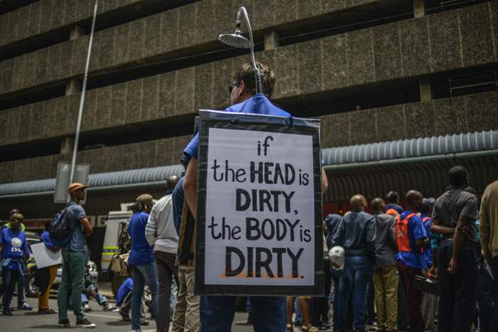 A political demonstrator mocks Zuma&#39;s “shower” comments