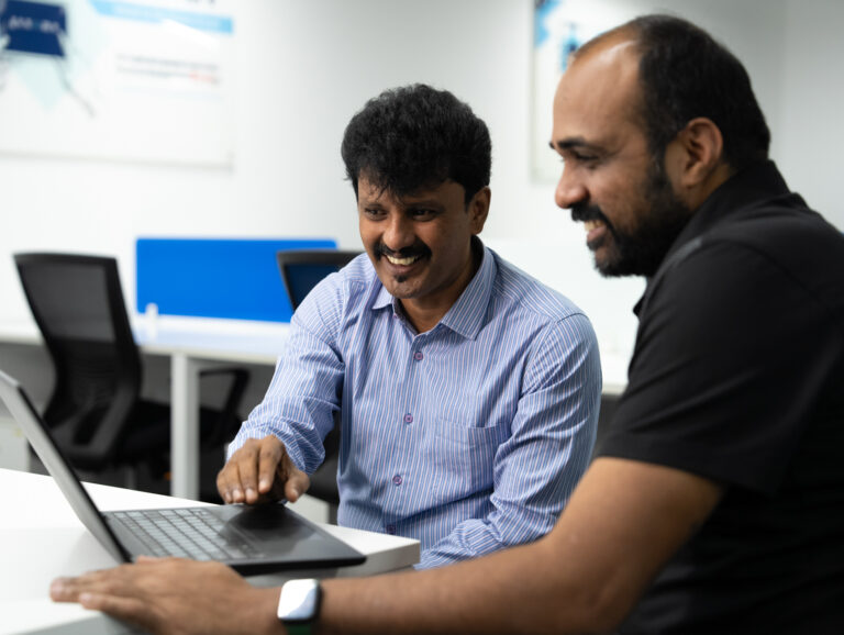 men collaborating at a laptop