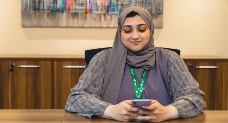 Woman holding a smartphone at a table