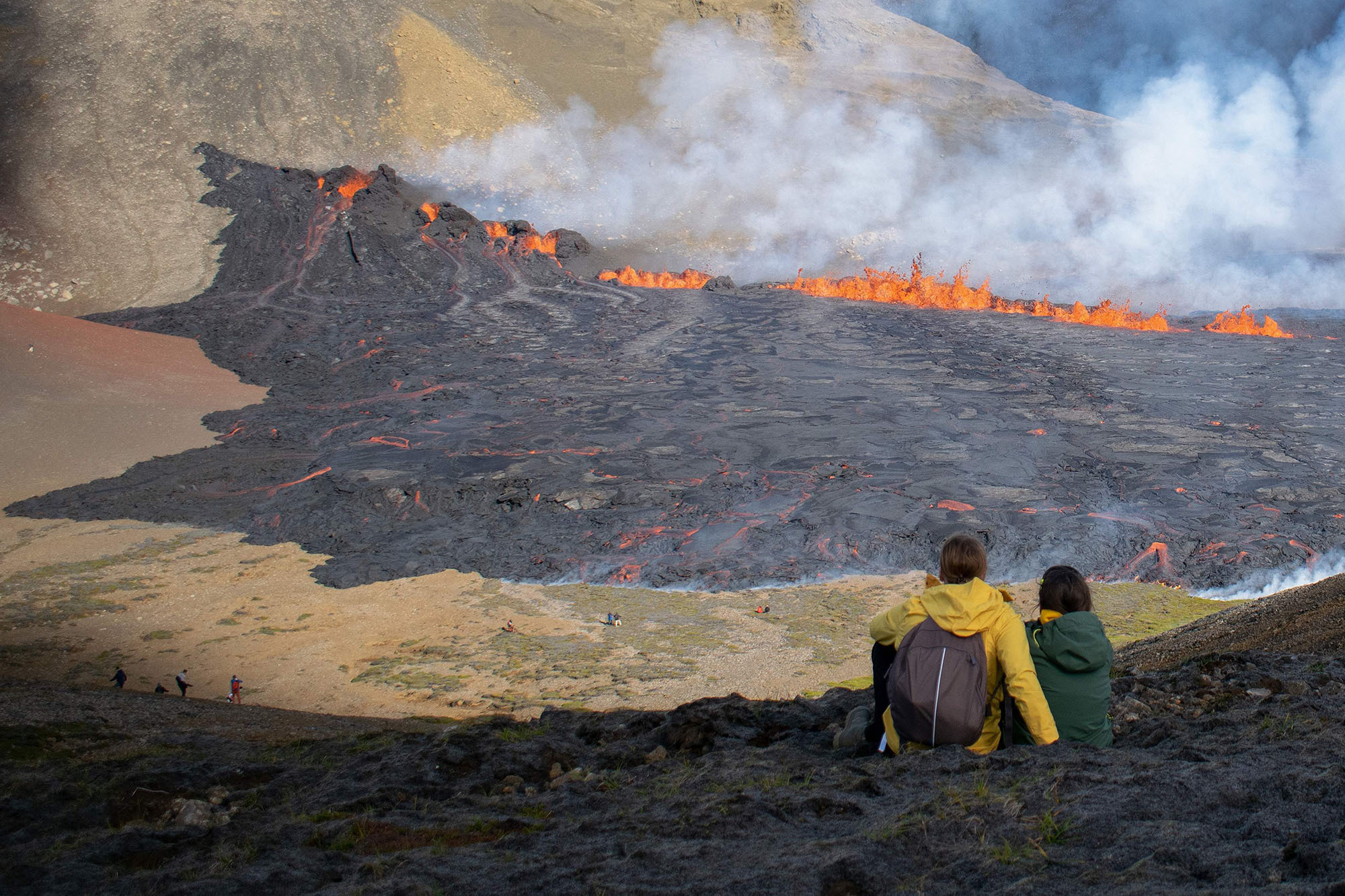 People watch lava flow after a volcano erupted on Aug. 3, 2022 in Grindavik, Iceland.