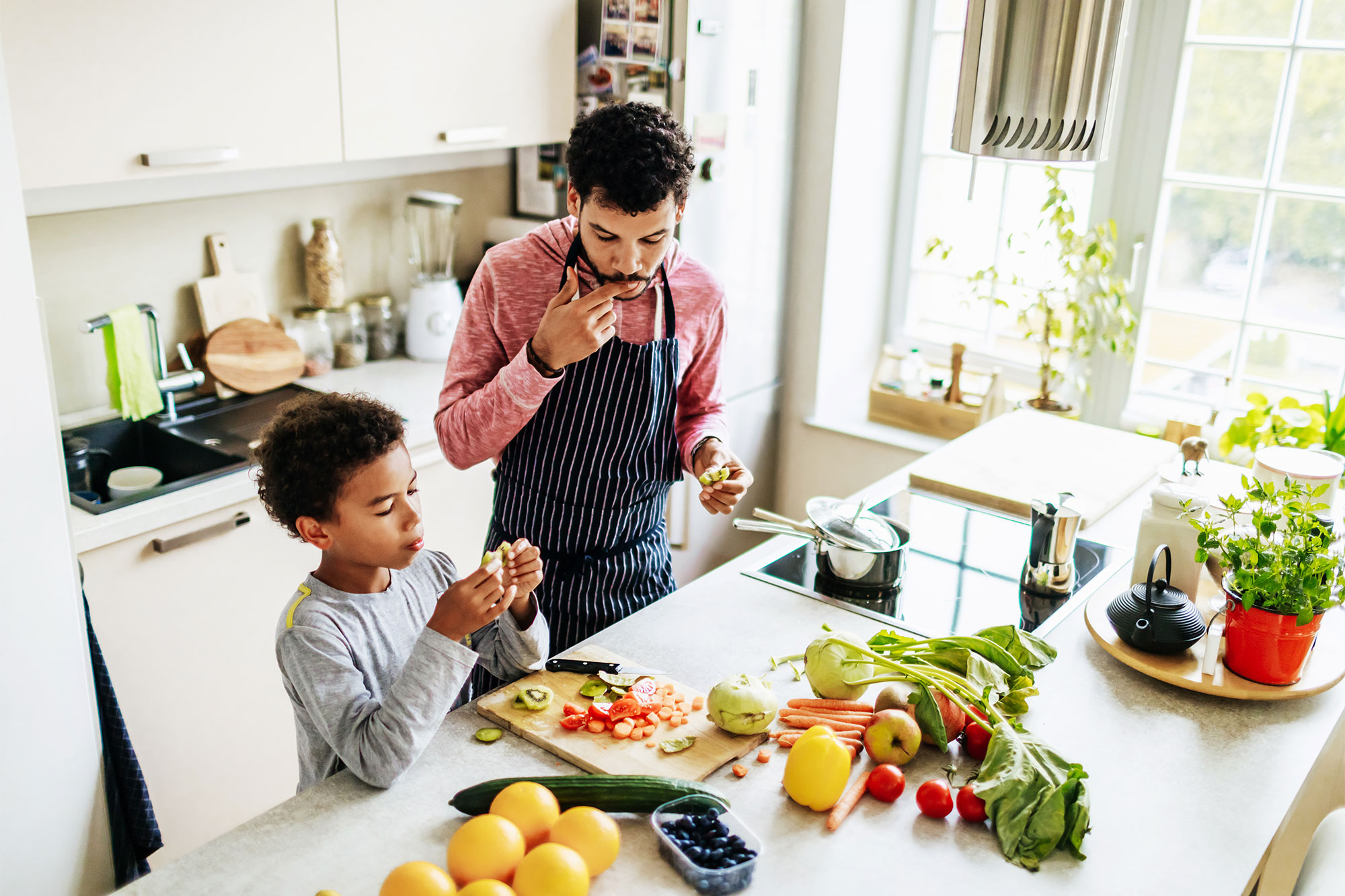 adult man and young boy cooking