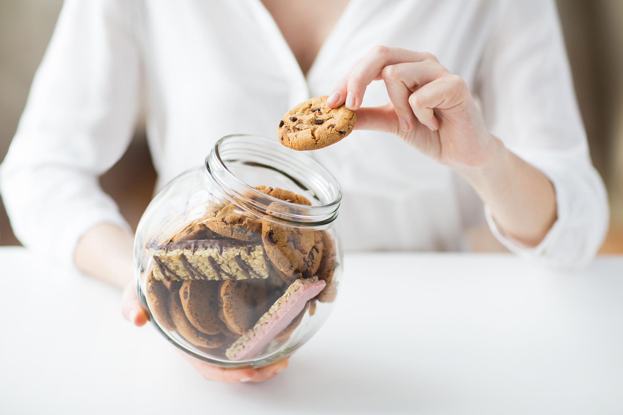 A woman with a cookie and a cookie jar