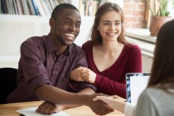 A young couple signs a loan together.