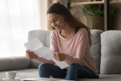 A young woman smiles at her student loan refinance.