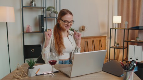 A young woman celebrates her student loan refinance.