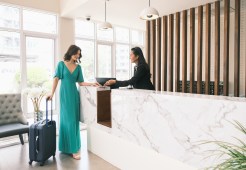 A woman signs into a hotel.