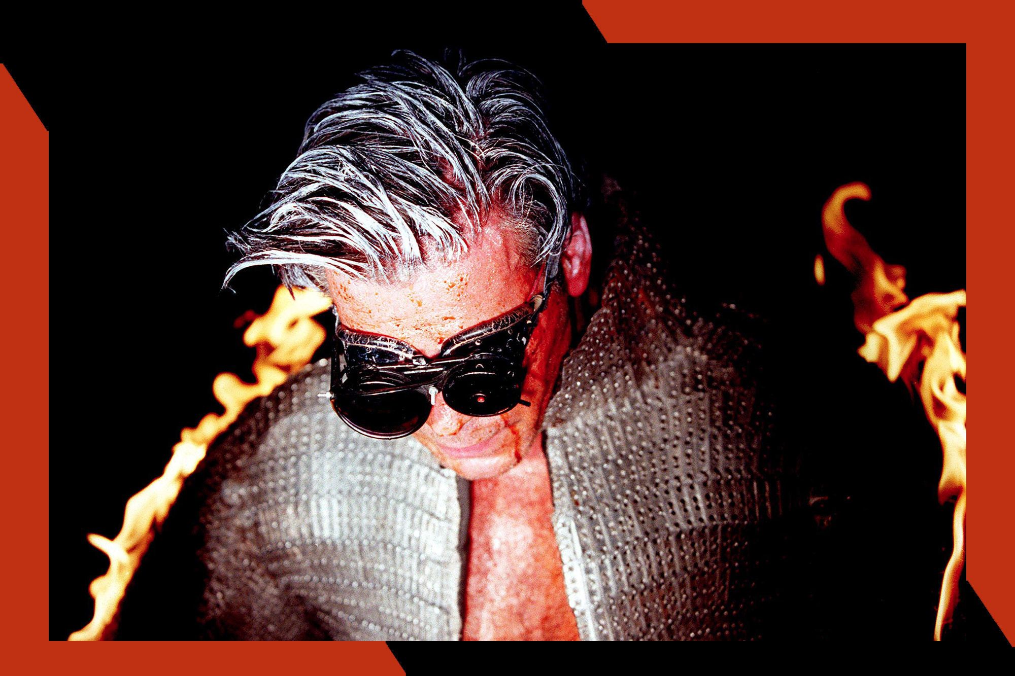 Till Lindemann wears thick glasses while looking down in a photo.