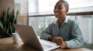 Young black woman smiling while looking at laptop